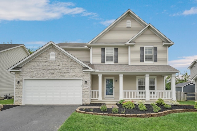 4441 Butler Farms Dr, Columbus, OH 43207 - traditional-style home featuring asphalt driveway, a porch, stone siding, an attached garage, and a front yard