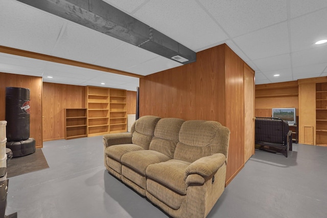 4441 Butler Farms Dr, Columbus, OH 43207 - living room featuring wood walls, concrete flooring, built in shelves, recessed lighting, and a drop ceiling