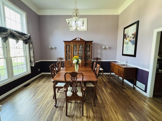 dining space with crown molding, baseboards, wood finished floors, and a chandelier