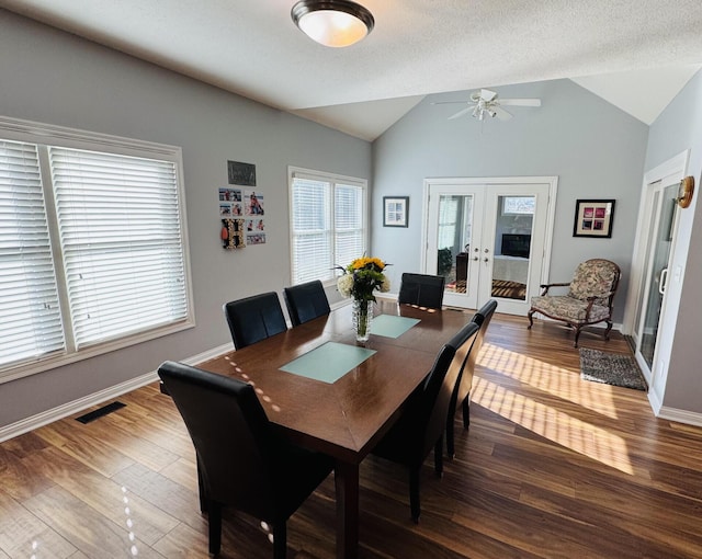 dining space featuring a ceiling fan, french doors, visible vents, vaulted ceiling, and wood finished floors