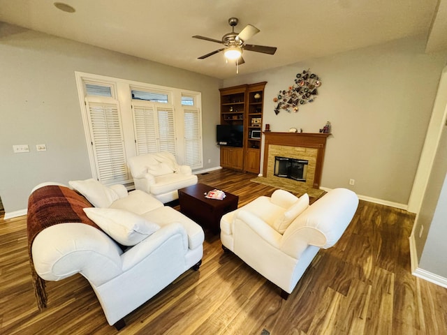 living area with baseboards, ceiling fan, and wood finished floors