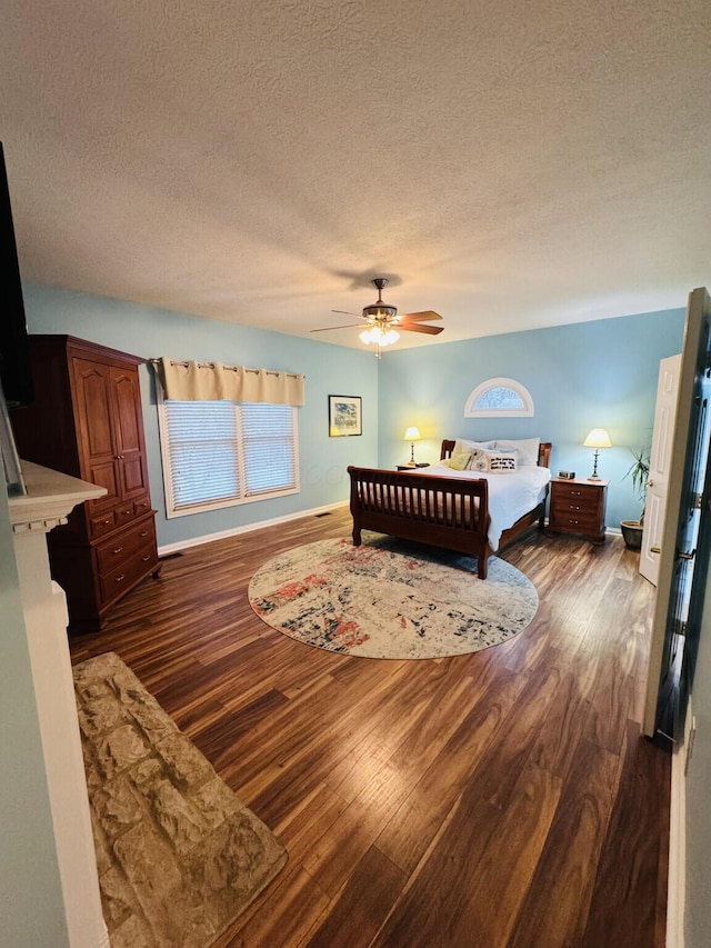 bedroom with a ceiling fan, a textured ceiling, and wood finished floors