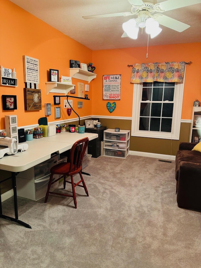 carpeted office featuring a ceiling fan and visible vents