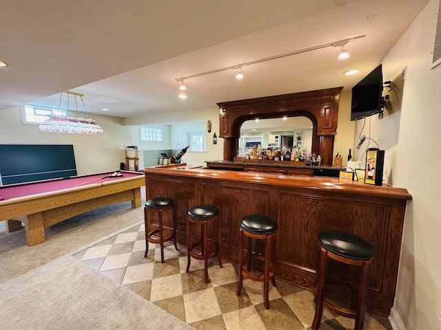 bar with pool table, a bar, and rail lighting