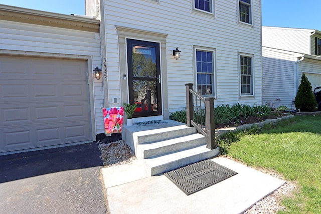 property entrance with a garage and driveway