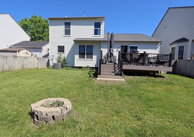 back of house featuring a lawn, a fenced backyard, central AC, and a deck