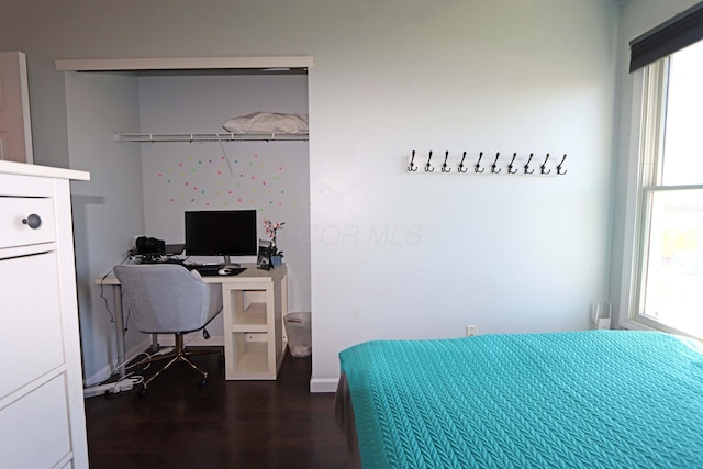 bedroom featuring baseboards, a closet, and dark wood-style floors