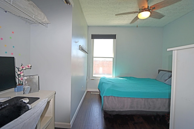 bedroom with a ceiling fan, baseboards, wood finished floors, and a textured ceiling