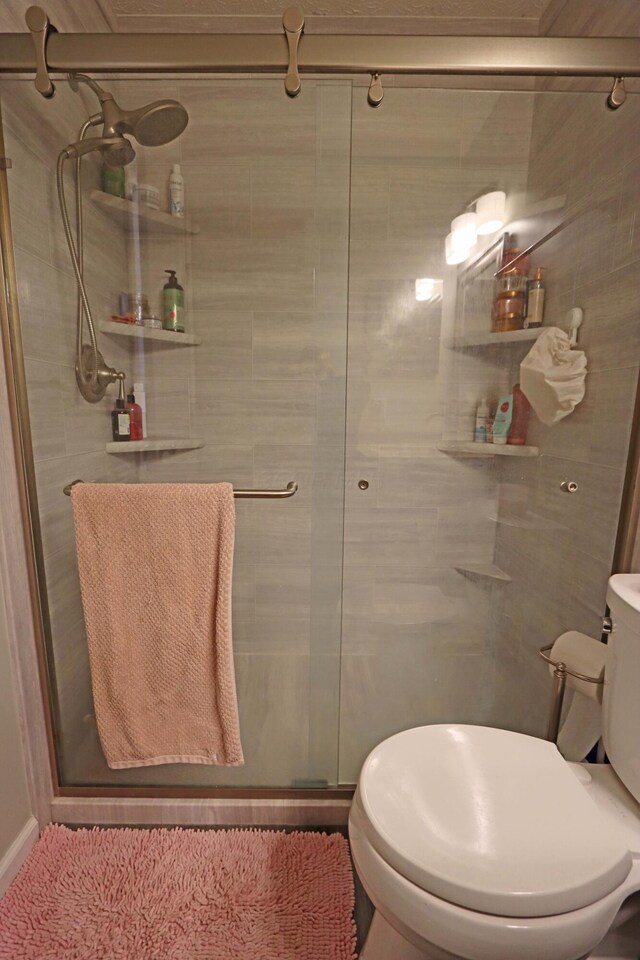 full bath with a shower stall and toilet