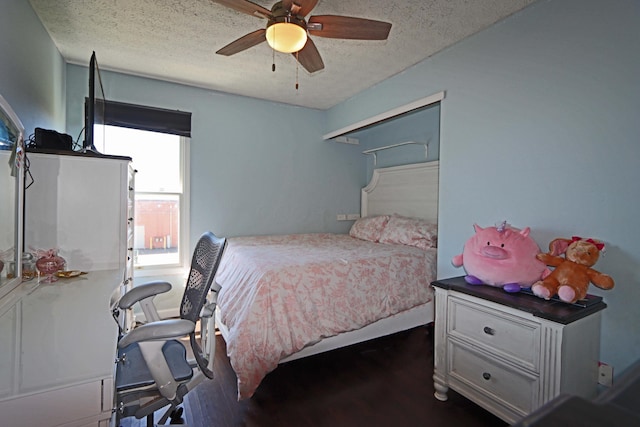 bedroom with a textured ceiling, ceiling fan, and dark wood-style floors