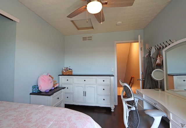 bedroom featuring a ceiling fan, visible vents, and dark wood finished floors