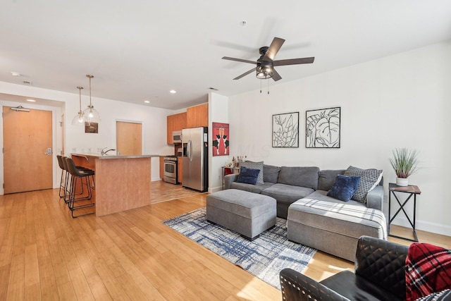 living area with a ceiling fan, recessed lighting, and light wood-style floors