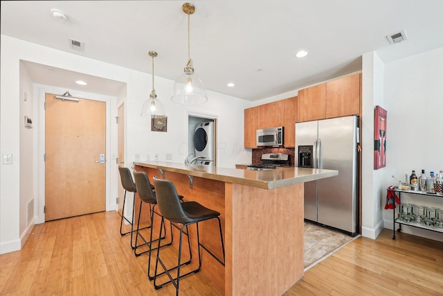 kitchen featuring visible vents, a breakfast bar area, recessed lighting, light wood-style flooring, and stainless steel appliances