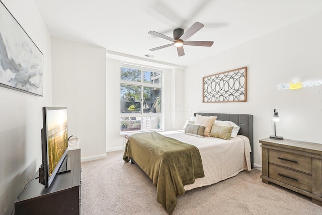bedroom featuring light colored carpet, a ceiling fan, baseboards, and visible vents
