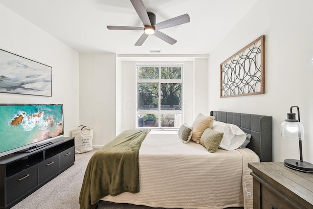 carpeted bedroom with a ceiling fan and visible vents