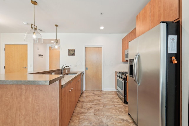 kitchen featuring appliances with stainless steel finishes, hanging light fixtures, brown cabinets, a sink, and a peninsula