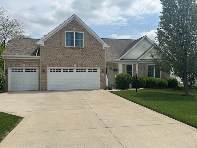 view of front of home featuring a shingled roof, an attached garage, a front lawn, brick siding, and driveway