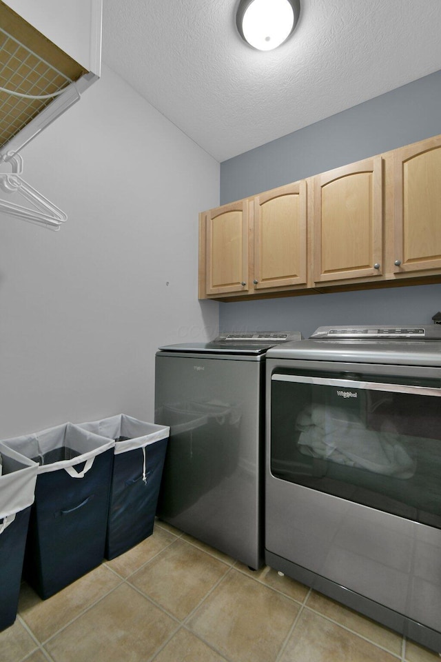 5914 Grant Run Estates Dr, Grove City, OH 43123 - clothes washing area featuring separate washer and dryer, a textured ceiling, cabinet space, and light tile patterned floors