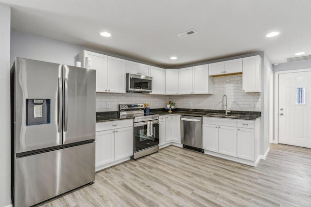 kitchen featuring a sink, light wood-style flooring, appliances with stainless steel finishes, and white cabinets