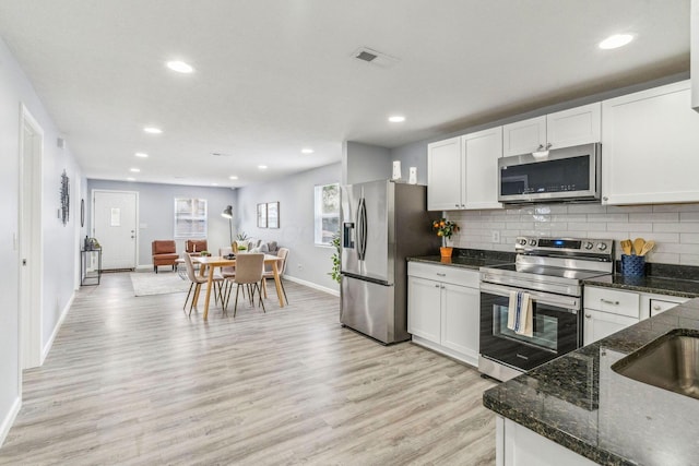 kitchen featuring visible vents, baseboards, light wood-type flooring, white cabinetry, and stainless steel appliances