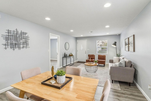 dining space with recessed lighting, baseboards, and light wood finished floors