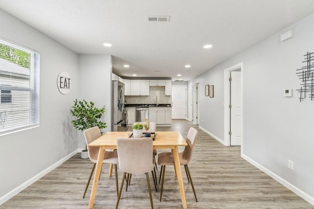 dining room featuring recessed lighting, baseboards, visible vents, and light wood-style floors