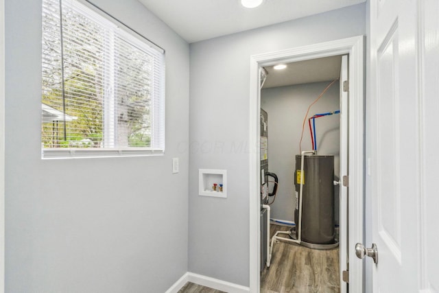 washroom featuring laundry area, hookup for a washing machine, water heater, baseboards, and wood finished floors