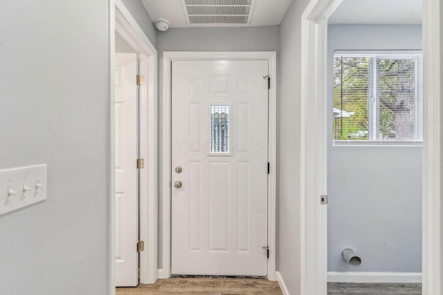 doorway featuring baseboards, visible vents, and light wood-style floors