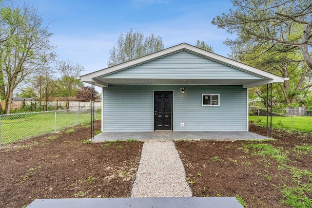 rear view of house with a lawn and a fenced backyard