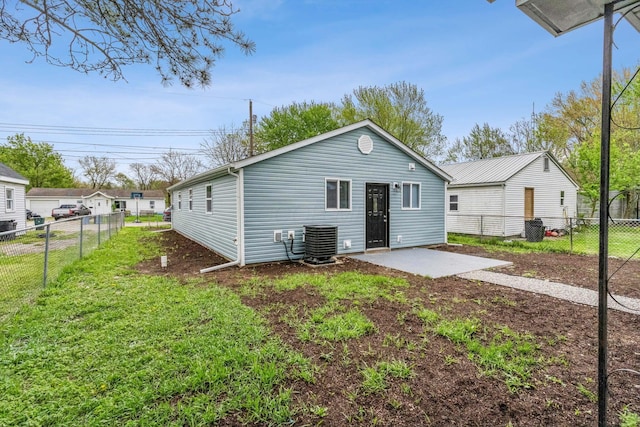 back of house with central air condition unit, a patio, a fenced backyard, and a lawn