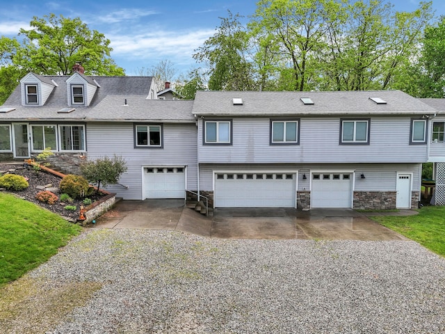 1108 W Church St, Newark, OH 43055 - view of front facade featuring concrete driveway, an attached garage, stone siding, and a chimney