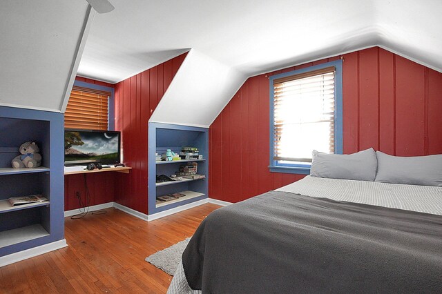 1108 W Church St, Newark, OH 43055 - bedroom with wood-type flooring, vaulted ceiling, and wood walls