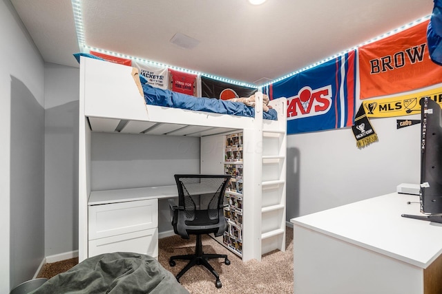 bedroom featuring baseboards, carpet, and built in study area