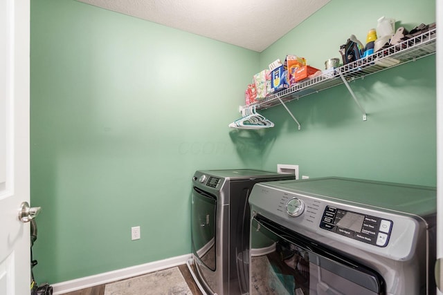 washroom with laundry area, a textured ceiling, baseboards, and independent washer and dryer