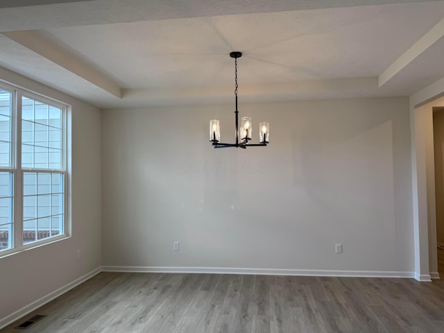 9920 Glenfield Ct Lot 51, Plain City, OH 43064 - unfurnished dining area with a tray ceiling, wood finished floors, a chandelier, and plenty of natural light