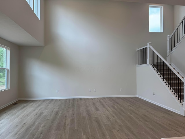 9920 Glenfield Ct Lot 51, Plain City, OH 43064 - unfurnished living room with stairway, wood finished floors, and a high ceiling