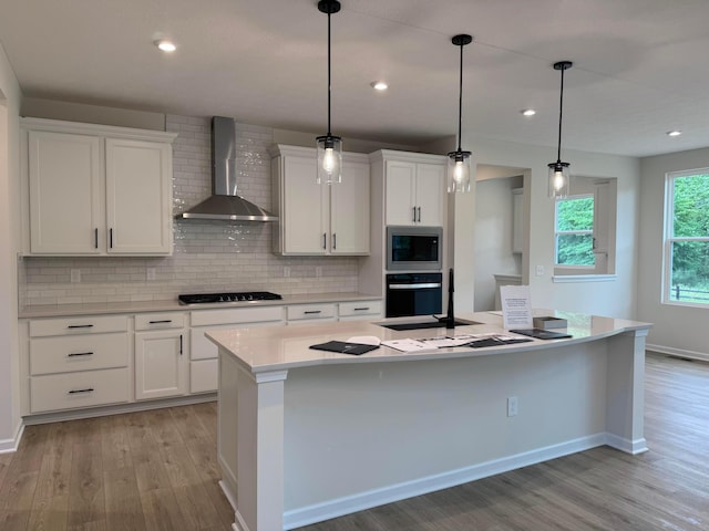 9920 Glenfield Ct Lot 51, Plain City, OH 43064 - kitchen featuring wall chimney exhaust hood, stainless steel microwave, light wood-type flooring, oven, and backsplash