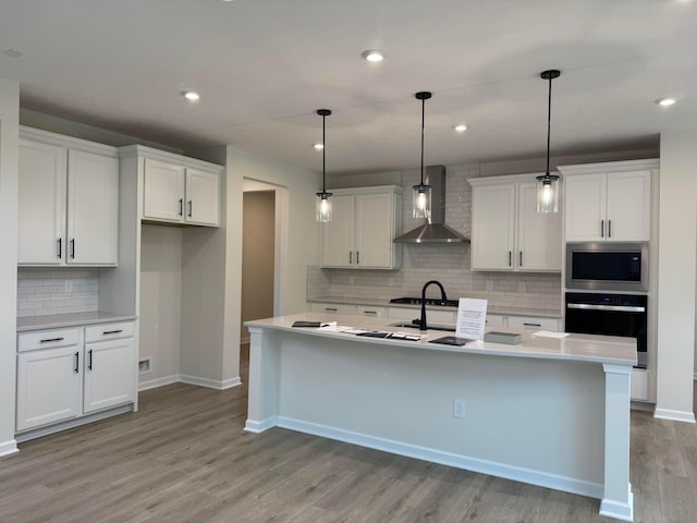 9920 Glenfield Ct Lot 51, Plain City, OH 43064 - kitchen with wall chimney exhaust hood, stainless steel microwave, black oven, tasteful backsplash, and white cabinetry