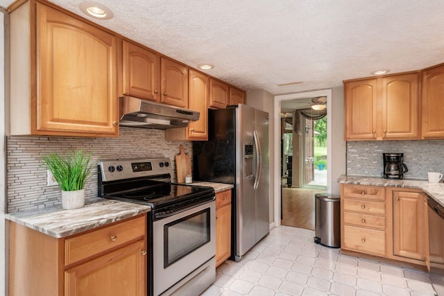 4917 Whistlewood Ln Unit 5, Westerville, OH 43081 - kitchen featuring decorative backsplash, a textured ceiling, appliances with stainless steel finishes, light stone counters, and under cabinet range hood