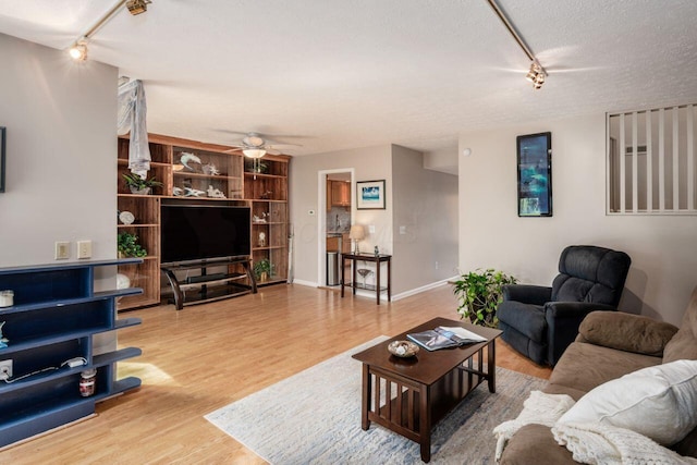 4917 Whistlewood Ln Unit 5, Westerville, OH 43081 - living room with ceiling fan, a textured ceiling, rail lighting, baseboards, and wood finished floors