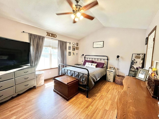bedroom with light wood-style floors, ceiling fan, and vaulted ceiling
