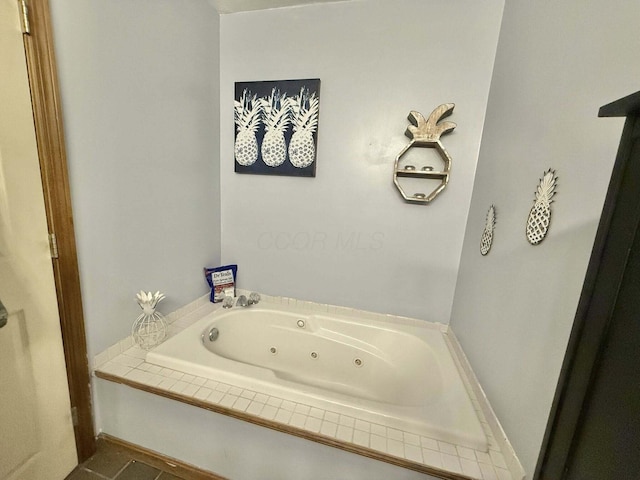 bathroom featuring a jetted tub and baseboards