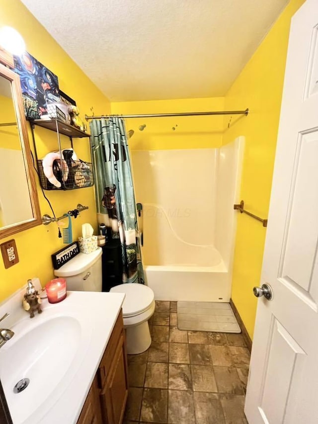 full bathroom featuring stone finish flooring, a textured ceiling, vanity, toilet, and shower / bath combo with shower curtain