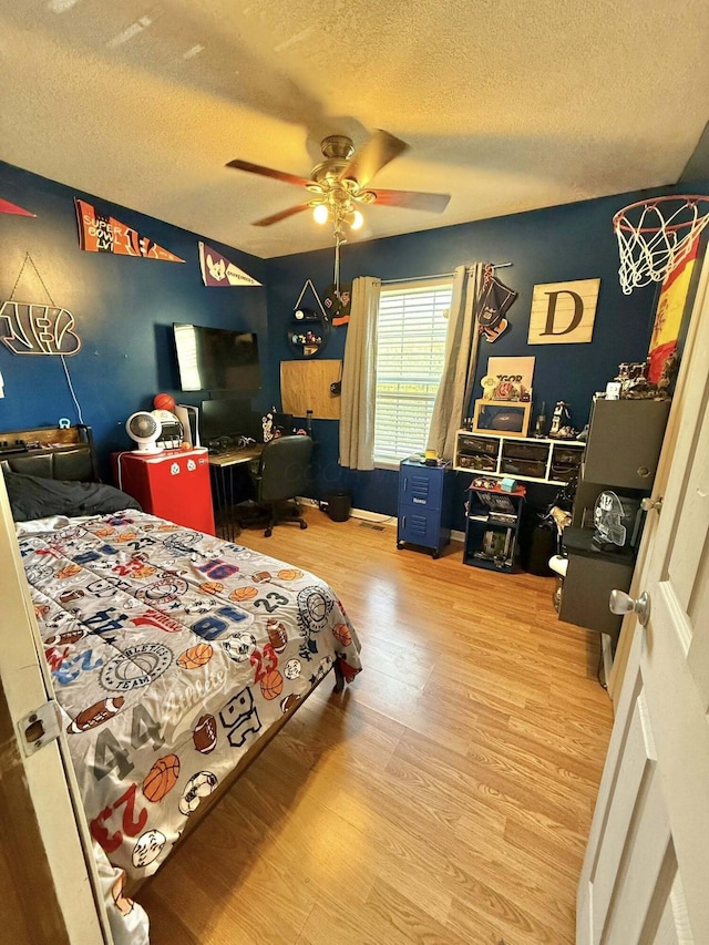bedroom featuring a ceiling fan, a textured ceiling, and wood finished floors