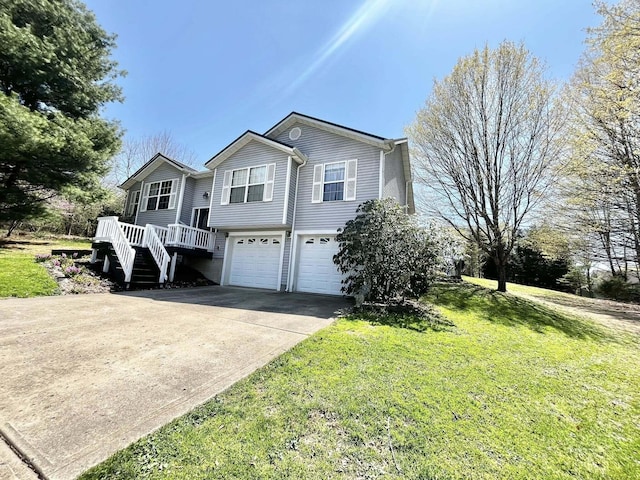 raised ranch featuring an attached garage, a front lawn, driveway, and stairway