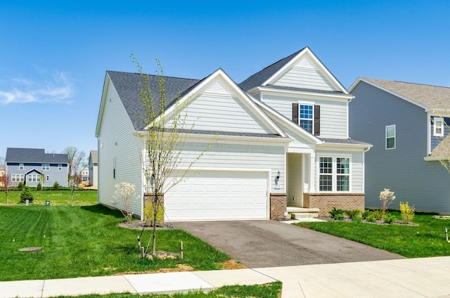 craftsman-style house featuring brick siding, a garage, aphalt driveway, and a front yard