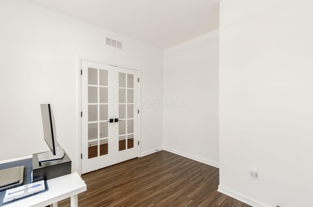 empty room featuring dark wood-style flooring, baseboards, visible vents, and french doors