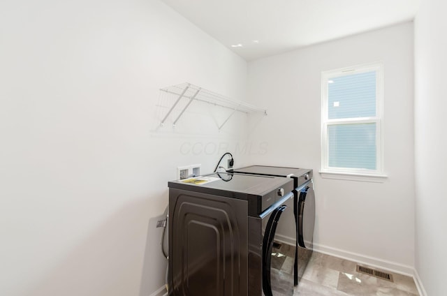 washroom with laundry area, baseboards, independent washer and dryer, and visible vents