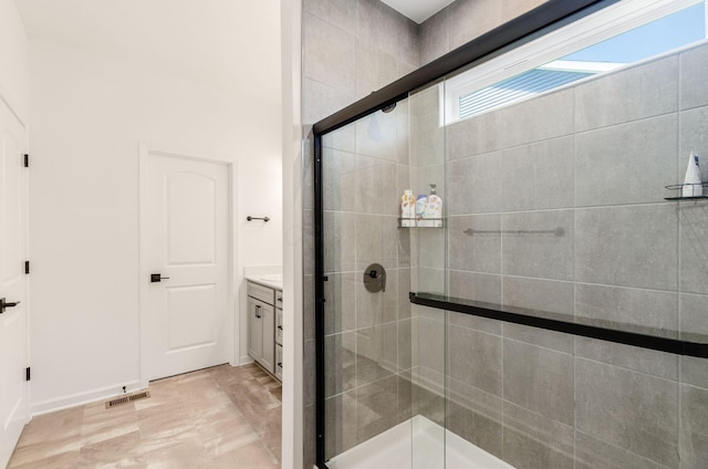 full bath featuring visible vents, baseboards, vanity, and a shower stall