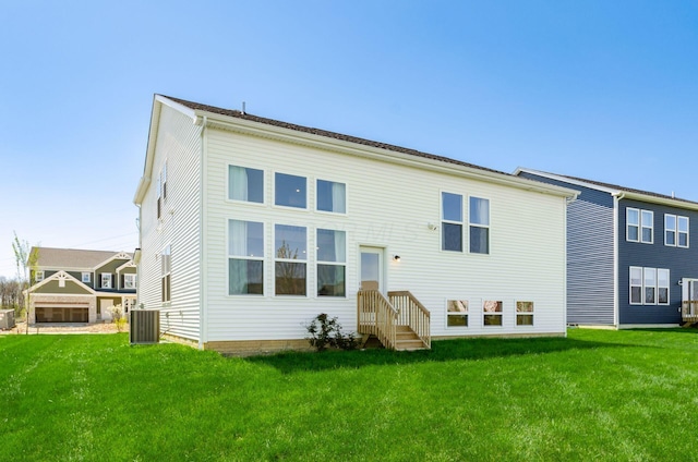 rear view of house featuring central AC unit and a yard